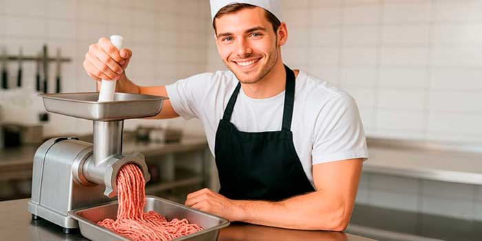 Joven cocinero picando carne
